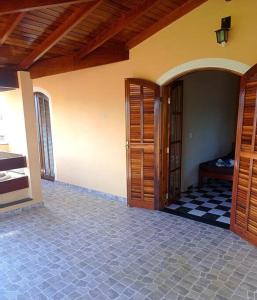 a room with wooden doors and a tile floor at Sobrado Quintal Grande 10 min do Centro in Caraguatatuba