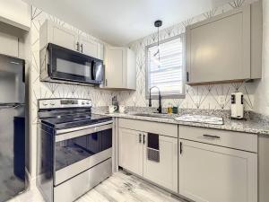 a kitchen with white cabinets and a stove and a microwave at 1br Orlando Studio Kitchenette Pets Ok in Orlando