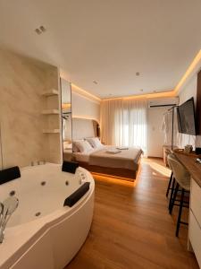 a hotel room with a tub and a bed at City break 1 LeD & Bath in Volos