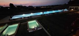 an overhead view of a swimming pool at night at Oikos Sani Suites in Sani Beach