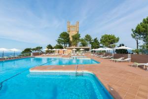 a large swimming pool with a clock tower in the background at Mercure Monte Igueldo in San Sebasti&aacute;n