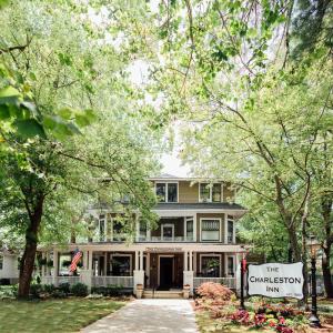The Charleston Inn Hendersonville NC في هيندرسونفيل: منزل كبير وامامه لافته