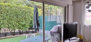 a living room with a television and an umbrella at Appart Chatou in Chatou