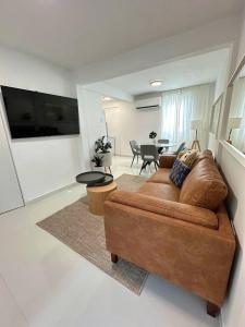 a living room with a brown couch and a table at Chic Apt in Vibrant Santurce V in San Juan
