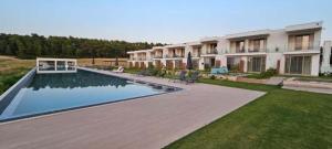 a house with a swimming pool in a yard at Oikos Sani Suites in Sani Beach