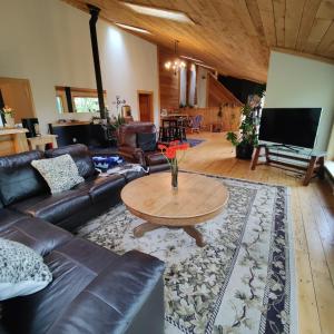 a living room with a leather couch and a table at Hummingbird B&B in Gabriola
