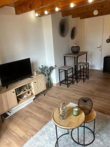 un salon avec une télévision, une table et des chaises dans l'établissement Appartement montagne, à Andon
