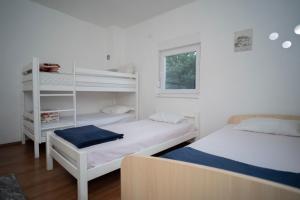 a bedroom with two beds and a window at Villa Počitelj in Čapljina