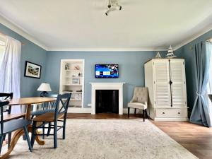 a living room with a table and a fireplace at Ballachulish House Apartment in Ballachulish