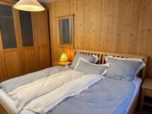 Un dormitorio con dos camas y una lámpara. en Lillibets Paradies am See, en Erlach