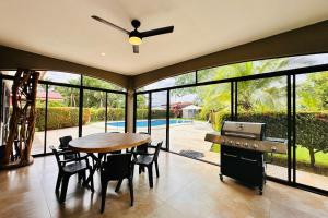 a dining room with a ceiling fan and a table and chairs at Villa Camino Corral By Vacation Pura Vida in Esterillos