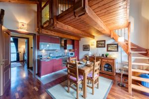 una cucina e una sala da pranzo con un tavolo di legno di La Casa di Camus - Happy Rentals a Bardonecchia