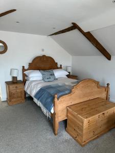 ein Schlafzimmer mit einem Holzbett und einem hölzernen Fußteil in der Unterkunft Shrimp Cottage - 3 bed renovated cottage with stunning sea views in Staithes
