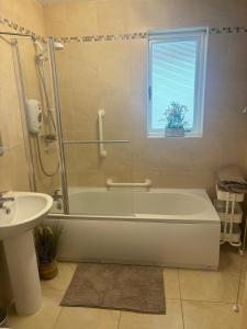 a bathroom with a bath tub and a sink at Micona in Newcastle