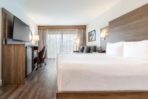 a hotel room with a bed and a flat screen tv at Atrium Hotel Vancouver in Vancouver