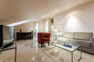 a living room with a couch and a tv at Exe Suites 33 in Madrid