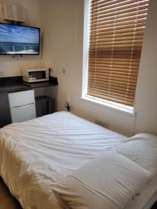 a bedroom with a white bed and a window at Heart of City DE1 Studio Apartment in Derby +8 photos