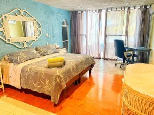 a bedroom with a bed with a mirror on the wall at Casa Saltwater Cowboy En La Playa - Beachfront Property in Chuburná