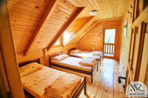 a room with three beds in a wooden cabin at Rafting Camp Modra Rijeka in Šćepan-Polje