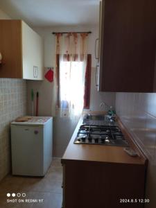 una cocina con estufa y encimera en Monolocale Dina's House, en Alghero 17 fotos más