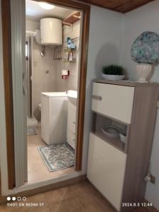 baño pequeño con fregadero y nevera en Monolocale Dina's House, en Alghero