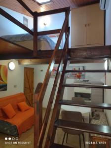 Una escalera de caracol en una habitación con una cama naranja. en Monolocale Dina's House, en Alghero
