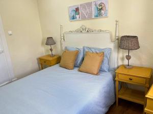 a bedroom with a bed with blue sheets and pillows at Casa do Viajante in Cabeção