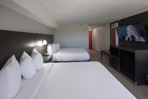 a hotel room with a bed and a flat screen tv at B&B Hotel Miami Airport in Miami