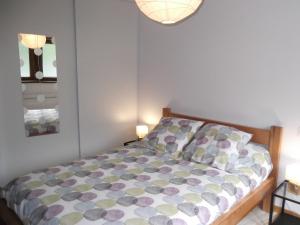 a bedroom with a bed with a colorful comforter at Chez Pépé in Génos