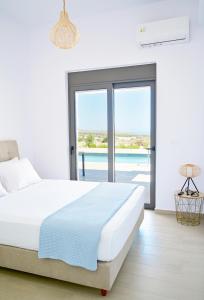 a bedroom with a bed and a view of a pool at Villa Elaia in Sitia +28 photos