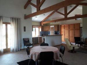 a living room with a table and chairs and a kitchen at Maison au calme dans la verdure in Raucoules