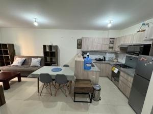 una cucina e un soggiorno con un tavolo e un divano di Departamento centrico y confortable a Cochabamba