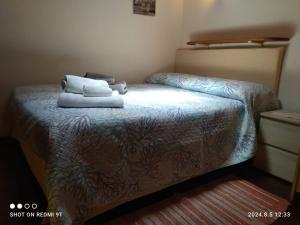 Un dormitorio con una cama con dos toallas encima. en Monolocale Dina's House, en Alghero