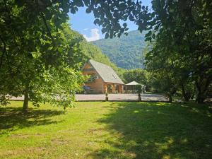 a log cabin in the middle of a field with trees at Villa Bosnia in Donji Vakuf