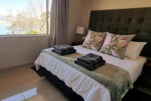 a bedroom with a bed with two towels on it at Waters View Villa, 5 Bedroom House in Hartbeespoort +33 photos