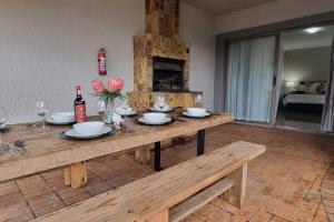 a wooden table with plates and flowers on top of it at Waters View Villa, 5 Bedroom House in Hartbeespoort
