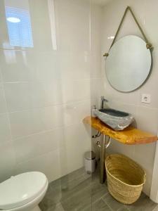 a bathroom with a toilet and a mirror at Casa Rural La Yeguada in Malcocinado +11 photos
