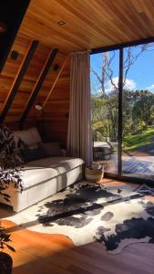 a bedroom with a bed and a large window at Cabana The Wild Urubici in Urubici