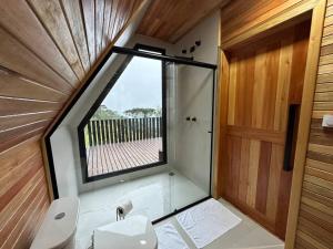 a bathroom with a window and a sink and a toilet at Cabana The Wild Urubici in Urubici