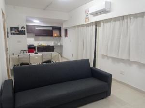 a living room with a black couch and a table at A y N Alojamiento in Lomas del Mirador