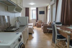 a kitchen and a living room with a stove top oven at Hotel Lile • სასტუმრო ლილე in Khulo