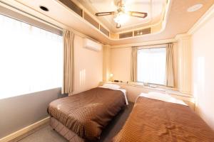 Postel nebo postele na pokoji v ubytování Reco Hotel Mikuni