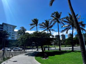 a park with palm trees and a street at 4 star Beachfront Hotel apartment in Noumea