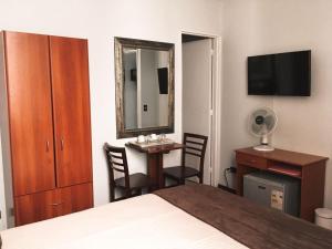 a hotel room with a desk and a mirror at Hotel Universitario in Santiago
