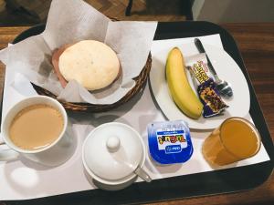 a tray with a basket of food and a sandwich and a cup of coffee at Hotel Universitario in Santiago