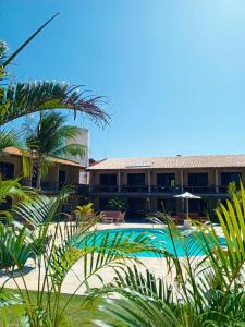 a resort with a swimming pool and palm trees at Hotel Pousada Cumbuco Gold in Cumbuco