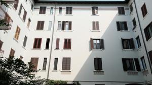 a tall white building with black windows at GARIBALDI ISOLA APARTMENTS - 80m from GARIBALDI station & 10min from CENTRALE station in Milan