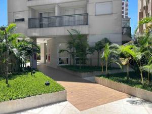 a large building with palm trees in front of it at LK1005 Espaçoso Apartamento Com Vista da Vibrante Rua Augusta in Sao Paulo