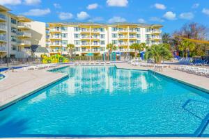 a swimming pool at a resort with chairs and a building at Litchfield Beach & Golf Resort in Pawleys Island