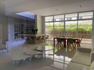 a living room with tables and chairs and a large window at LK1005 Espaçoso Apartamento Com Vista da Vibrante Rua Augusta in Sao Paulo